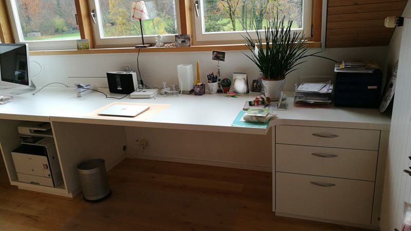 Massgeschneiderter Schreibtisch in schmalen Büro optimal eingepasst für maximale Arbeitsfläche ohne einzuengen.